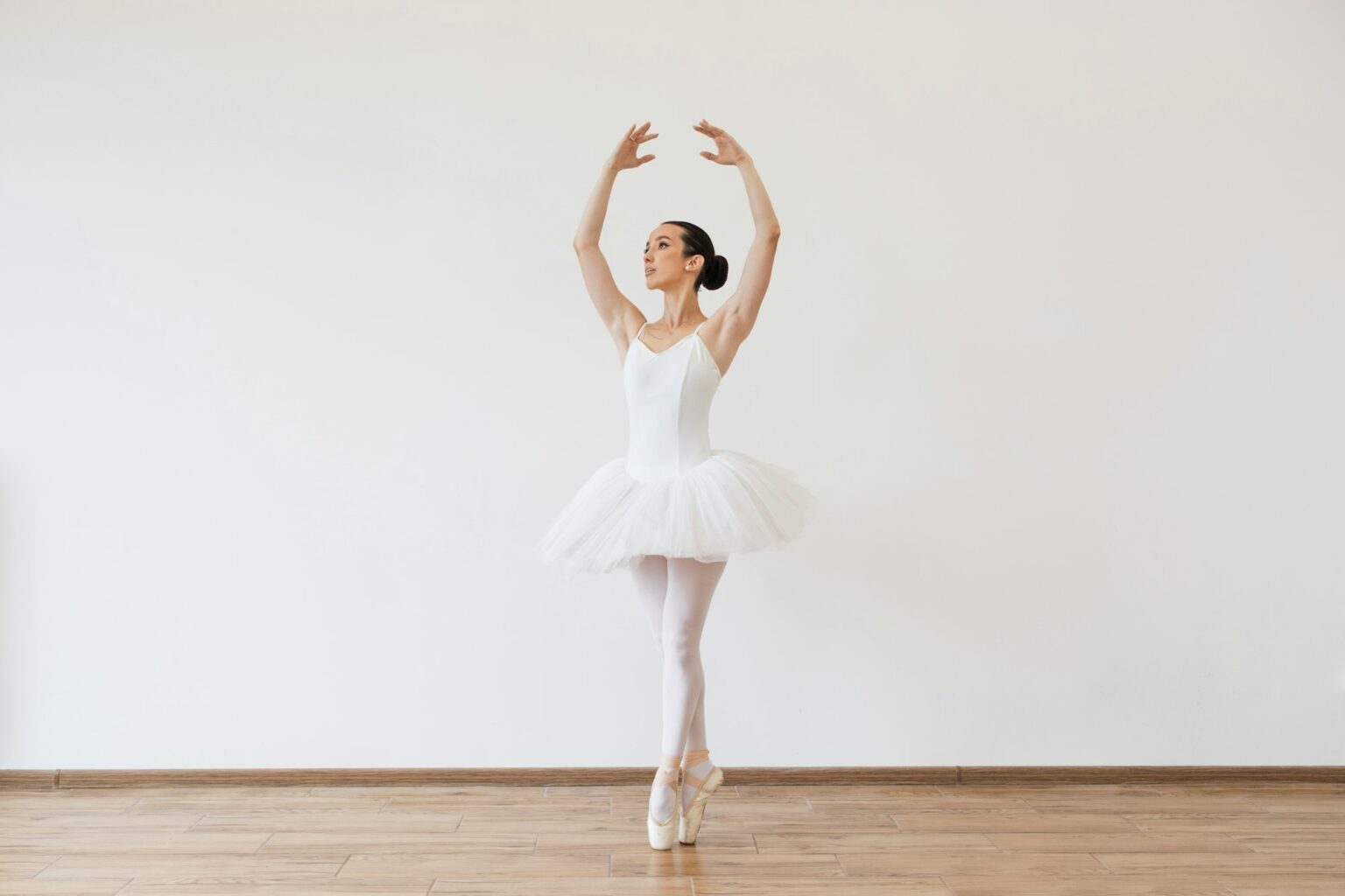 Beautiful female ballet dancer bending over effortless on stage with harmony