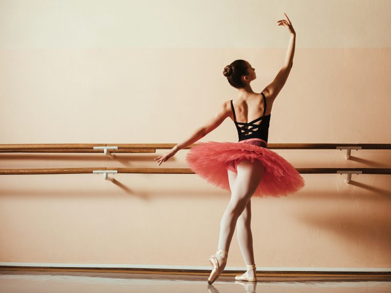 Back view of graceful female ballet dancer at ballet studio.